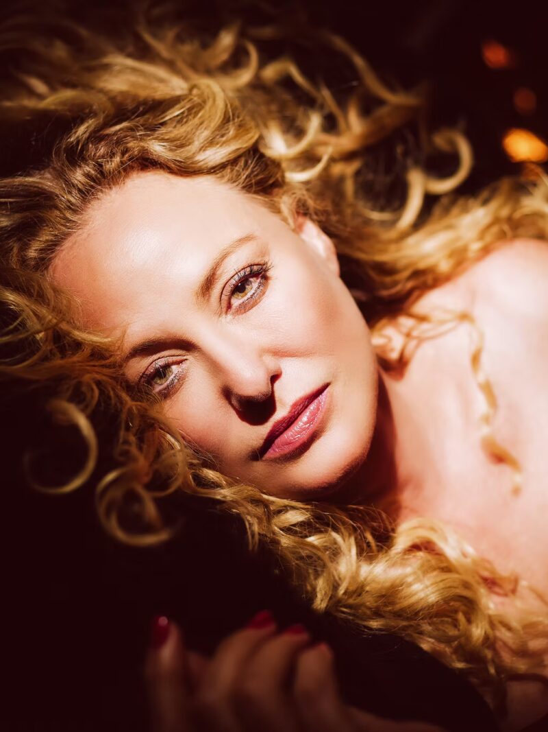 nick holmes portrait woman blonde curls overhead warm glamorous